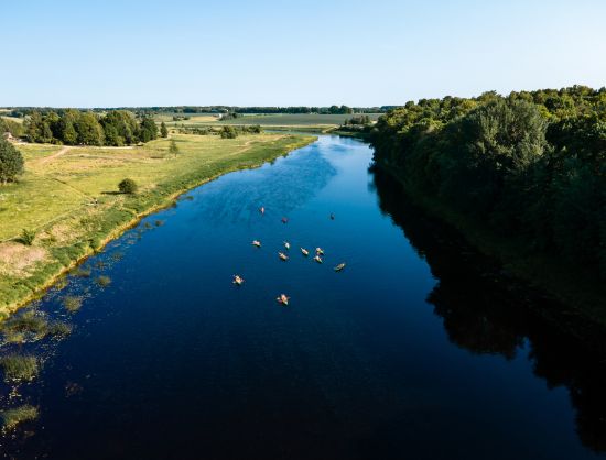 Brāļu laivas ar laivotājiem upē tālumā