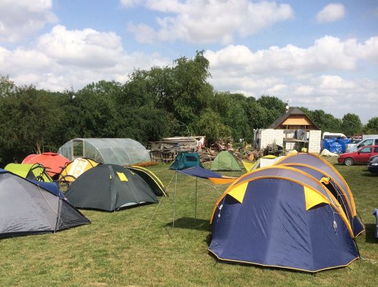Rundāles atpūtas centrs/ Rundāles kempings vasaras dienā. Zaļā zālājā izvietotas vairākas dažādu krāsu teltis,  Te&scaron;u vieta Bauskas novadā.