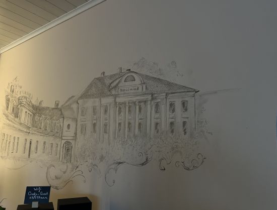 Interjers kafejnīcā Grāfs - sienas zīmējums, kur attēlota Kaucmindes muiža.