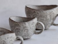 Eleganti 'Laima Ceramics' kolekcijas trauki: attēlā minimālistiska stila krūzes pieklusinātos, dabas iedvesmotos toņos. Katrs priek&scaron;mets ir unikāls mākslas darbs ar smalku tekstūru.